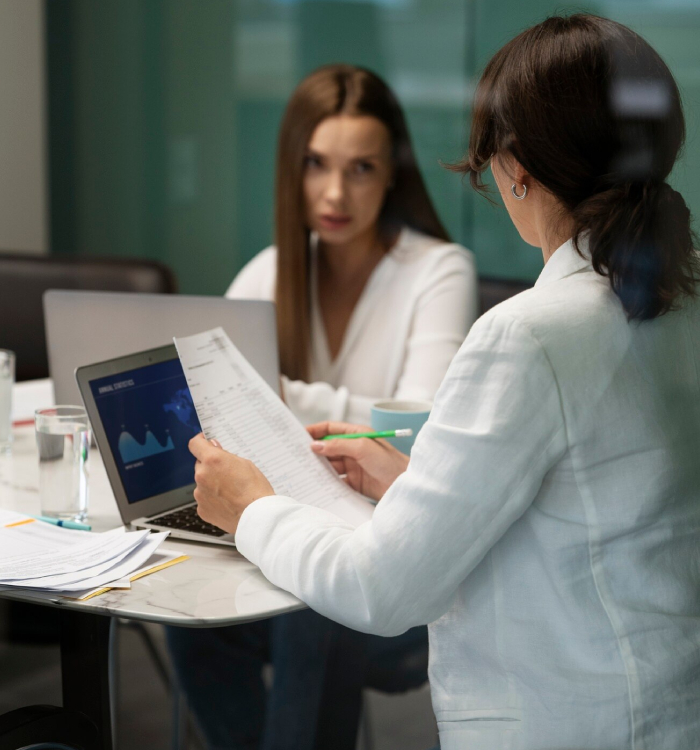 Clinical supervisor reviewing healthcare documents and discussing professional practice with a clinician during a supervision meeting.